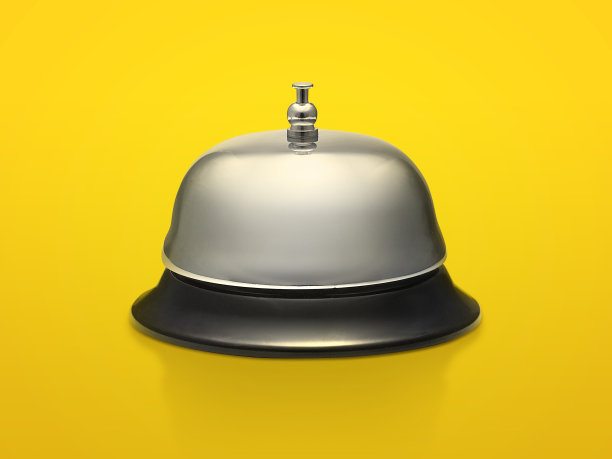 酒店服务理念：银色接待铃，明亮橙色背景图片下载