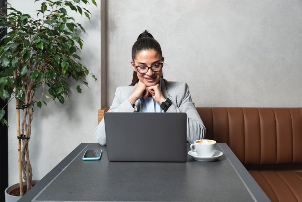 午休时间坐在咖啡店里喝咖啡，用笔记本电脑工作的年轻女商人自由职业者为外国公司开展新项目图片下载