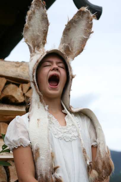 可爱的复活节兔女郎在柴堆前又唱又叫。图片下载