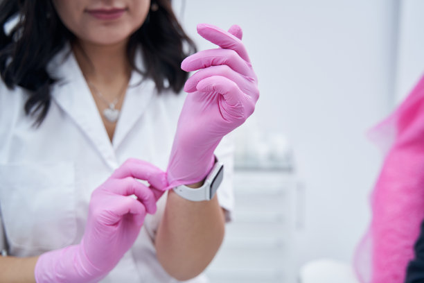 女美容师戴上粉红色无菌手套的特写照片图片下载
