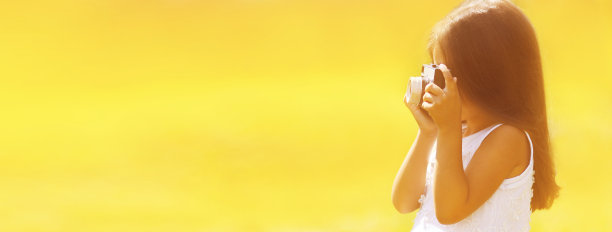 小女孩的肖像与电影相机拍摄的照片在阳光明媚的夏天的背景，横幅空白拷贝空间的广告文字图片下载