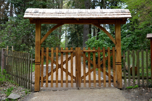 木制击剑运动场。木板门，门上有屋顶。带有木制排水沟的土路。带屋顶和垂直栅栏的小门图片下载