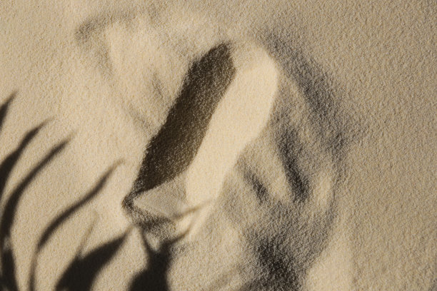 背景与柔和的沙子为产品介绍。展示化妆产品的t台。图片下载