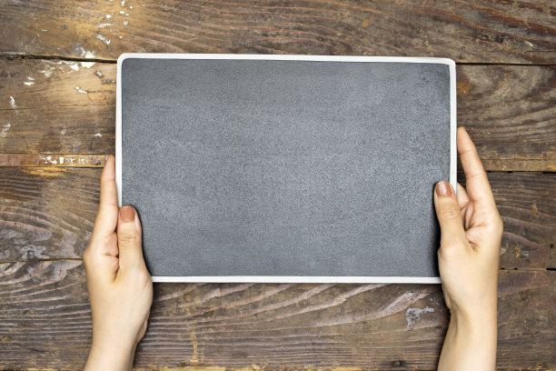 手拿白板放在木桌上图片下载