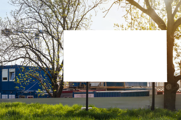 建筑工地前的空白广告牌。一个阳光明媚的日子，公寓正在建设中。图片下载