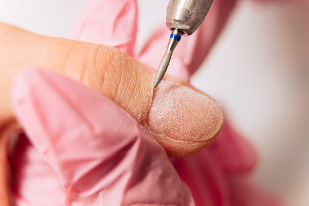 美甲过程：美甲师使用自动机器抛光指甲，去除抛光钻。图片下载