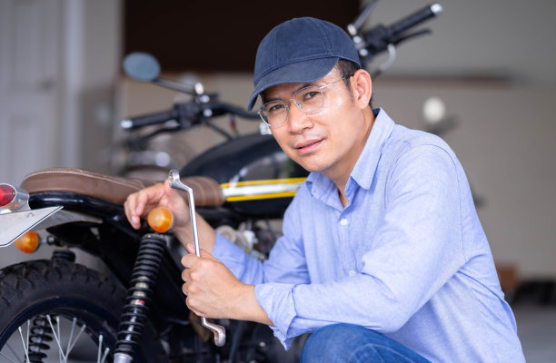 机械师在车库或车间维修过程中检查经典摩托车的照片。图片下载