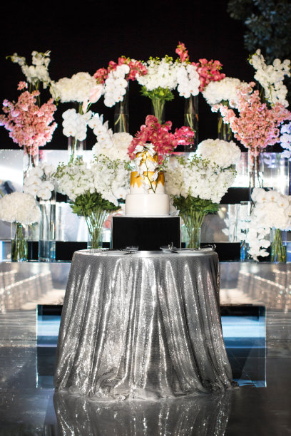 多层婚礼蛋糕与鲜花在银桌上图片下载