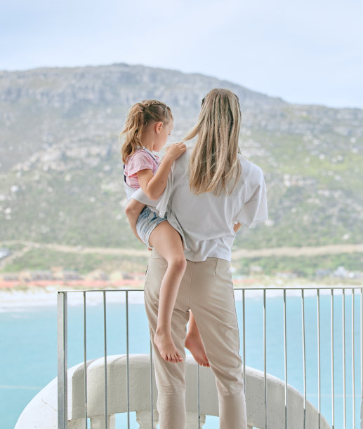 一个不知名的母亲和女儿在家里的阳台上欣赏景色的照片图片下载