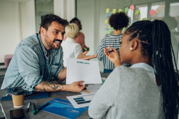 两个多种族的同事在办公室开会图片下载