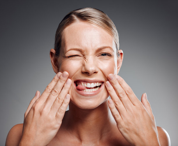 美丽成熟的女人在工作室对灰色背景摆姿势图片下载