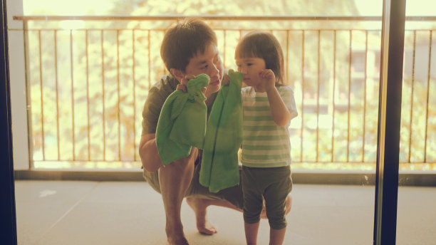 小女孩和她爸爸一起擦玻璃。图片下载