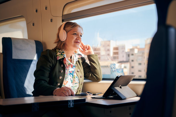 一位中年妇女在乘火车旅行时听音乐图片下载