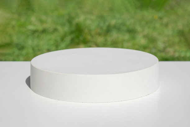 讲台上演讲。模糊的绿草背景。抽象的几何形式。缸石球体。的影子。现场展示产品。展示,显示情况。时尚的阳光。前视图。3 d图片下载