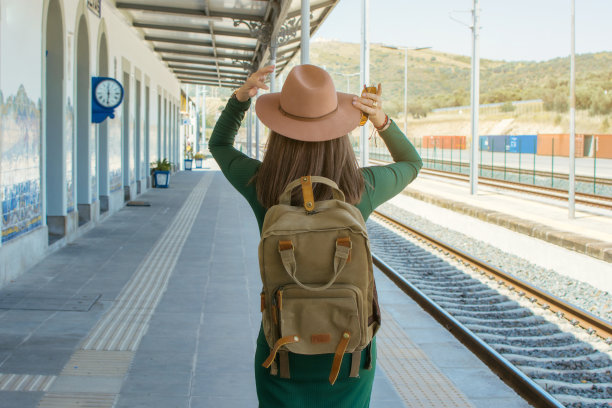 一个女人背着背包和帽子在火车站旅行的后视图。旅行的概念。带拷贝空间的图像。图片下载
