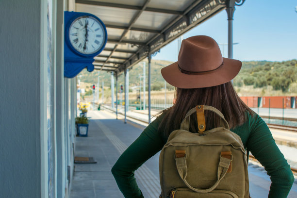 一个女人背着背包和帽子在火车站旅行的后视图。旅行的概念。带拷贝空间的图像。图片下载