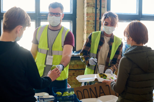 男人递苹果给男孩，女人将食物放入难民容器图片下载