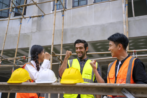 蓝领工人在建筑工地与同事一起工作。图片下载