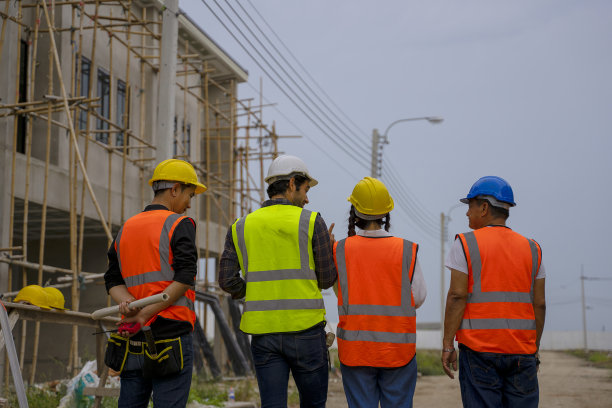 蓝领工人在建筑工地与同事一起工作。图片下载