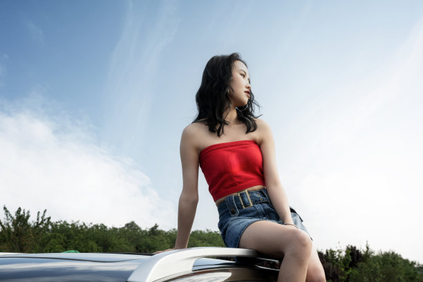 穿着红色衣服的时髦女人坐在屋顶上图片下载