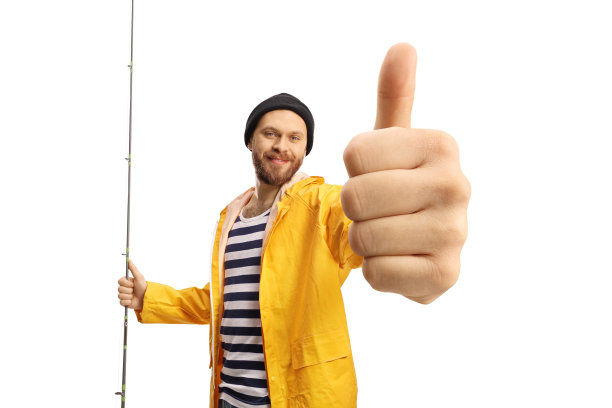 穿着黄色雨衣的渔夫微笑着，手里拿着鱼竿，竖起大拇指图片下载