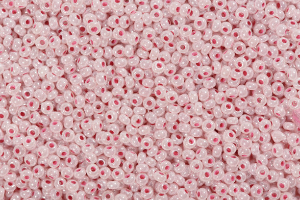 淡珊瑚，粉红色玻璃种子珠背景。图片下载