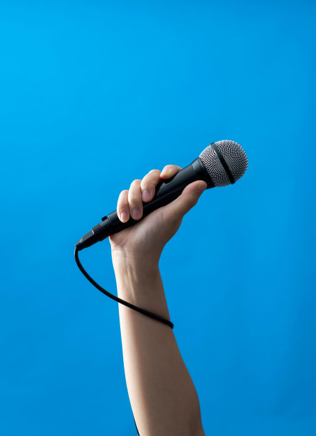 手拿麦克风，蓝色背景图片下载