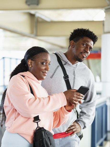 一对黑人夫妇在站台上四处张望，等待着图片下载