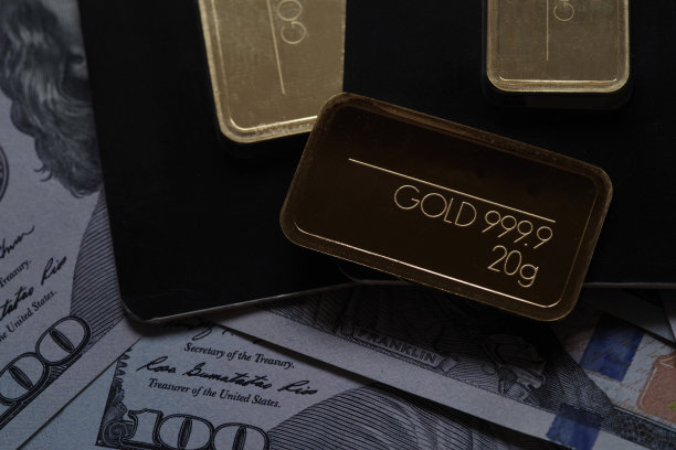 铸造的金条在美元纸币的背景下，纯度为999.9图片下载