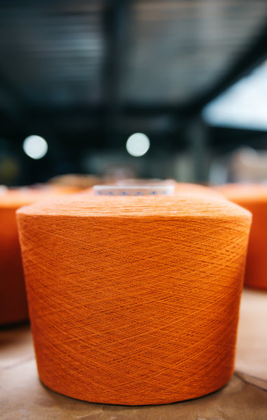 棉纱厂的线轴或线轴上的橙色棉纱线。图片下载
