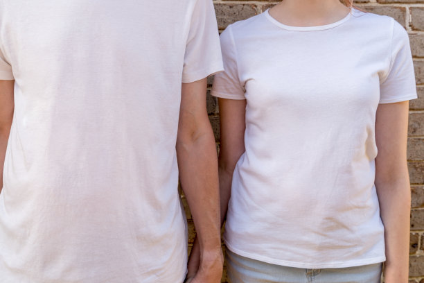 一对夫妇穿着砖墙背景上的白色t恤模型。模板样式复制空间图片下载
