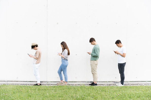 排队时使用手机的青少年图片下载