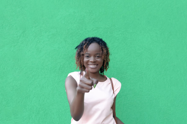 绿色背景上微笑的美丽非洲裔美国女人。积极的情感。漂亮的人图片下载