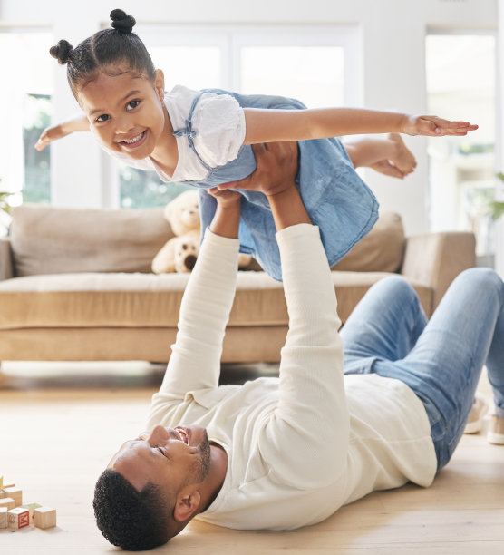 这张照片是一对年轻的父女在家里的地板上玩耍时的亲密关系图片下载