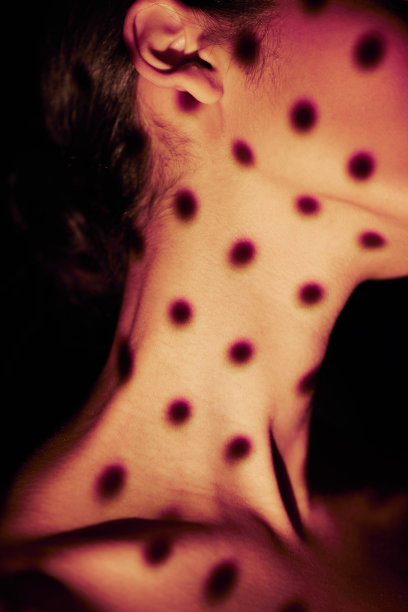 在一间工作室里，一个黑人背景下，一个混血儿女人的脖子被孤立的特写。西班牙模特在艺术和创意点光源下摆姿势。脖子上有黑圈灯的女人的头像图片下载