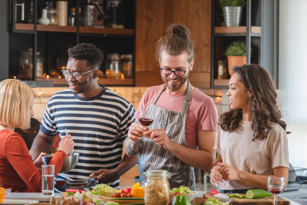 年轻人在家里举行节日聚会，准备食物，喝酒，聊天，享受图片下载