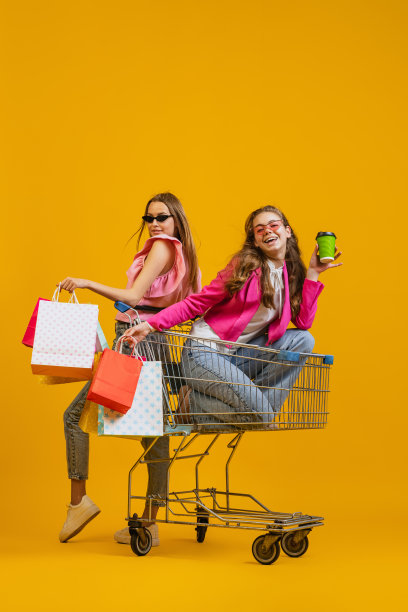 有趣的购物时间。酷年轻快乐的女孩去购物与购物车孤立在明亮的黄色背景。销售概念，黑色星期五，折扣，情绪图片下载