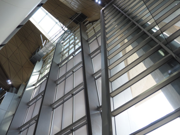 磨光墙壁。高的天花板。内部是玻璃的。大窗户，光线充足。公共场所、火车站、购物中心装饰。金属支架和支撑梁。图片下载