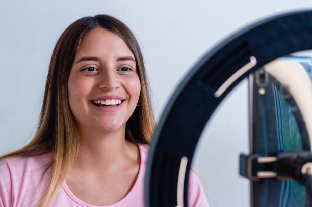 年轻女子内容生成器用她的手机和一圈光拍了一段视频图片下载