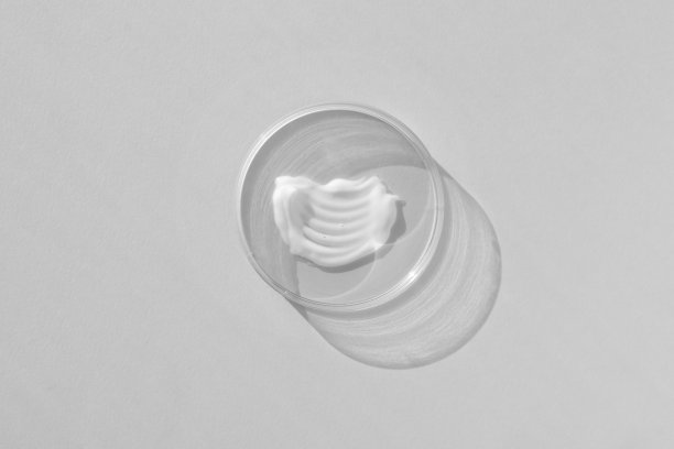 白色奶油质地的皮氏培养皿在灰色背景。化妆品实验室研究的概念。涂抹护肤品化妆品。健康美容理念图片下载