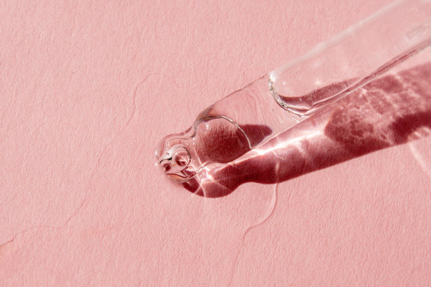 带液体透明质酸的移液管，单色粉红色背景。化妆品和保健概念特写图片下载