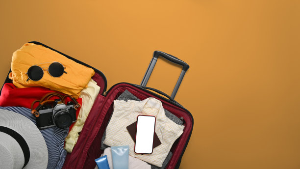 上图是米色背景的手提箱，带有太阳镜、相机、护照和帽子。为暑假做准备。图片下载
