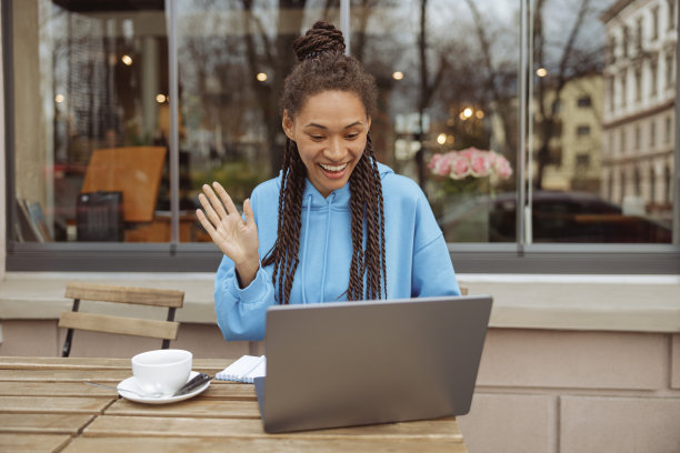 欢快时尚的年轻女性视频聊天和挥手与相机。视频电话。图片下载