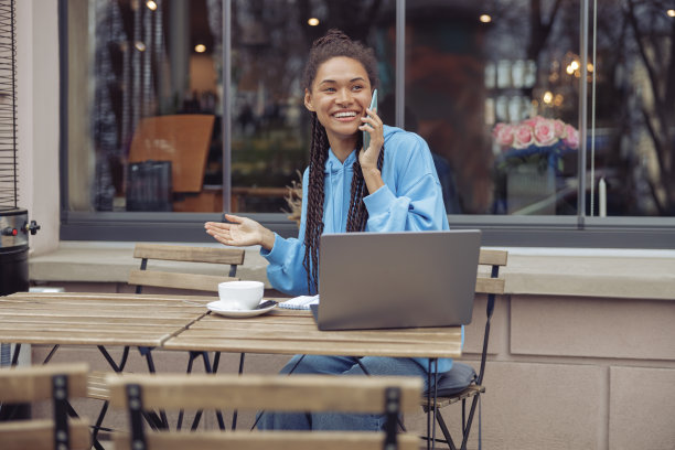 迷人开朗的年轻女性在咖啡馆喝咖啡时讲手机。图片下载