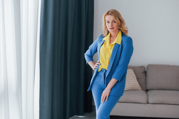 女士穿着正式的蓝黄色裤套装在室内图片下载