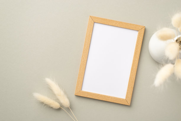 顶视图照片的木制相框和白色陶瓷花瓶的花束白色lagurus花在粉彩灰色的背景与copyspace图片下载