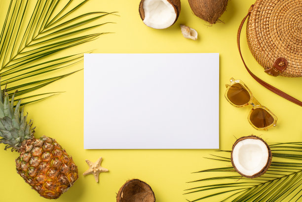 暑假的概念。纸圆藤袋太阳镜贝壳海星热带水果椰子菠萝和棕榈叶的顶部视图照片在孤立的黄色背景与空白空间图片下载