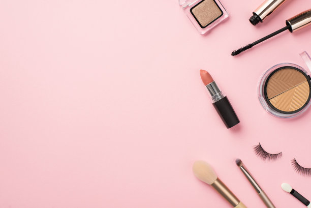 构成美的概念。俯视图照片的轮廓调色板，口红，假睫毛，化妆刷，睫毛膏和眼影粉彩粉红色的背景与空白图片下载