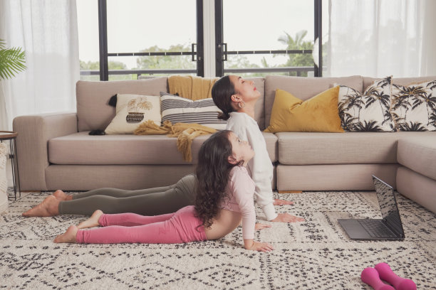 亚洲母亲和混血女儿在家一起练习瑜伽，家庭在线学习，健康生活方式理念图片下载