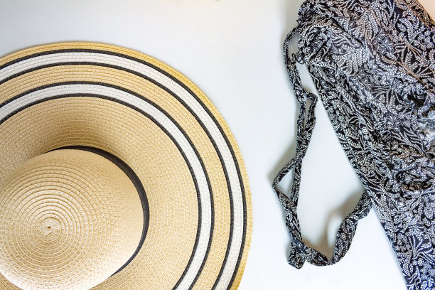 一顶女士柳条帽，上面是白色背景上的黑白连衣裙图片下载